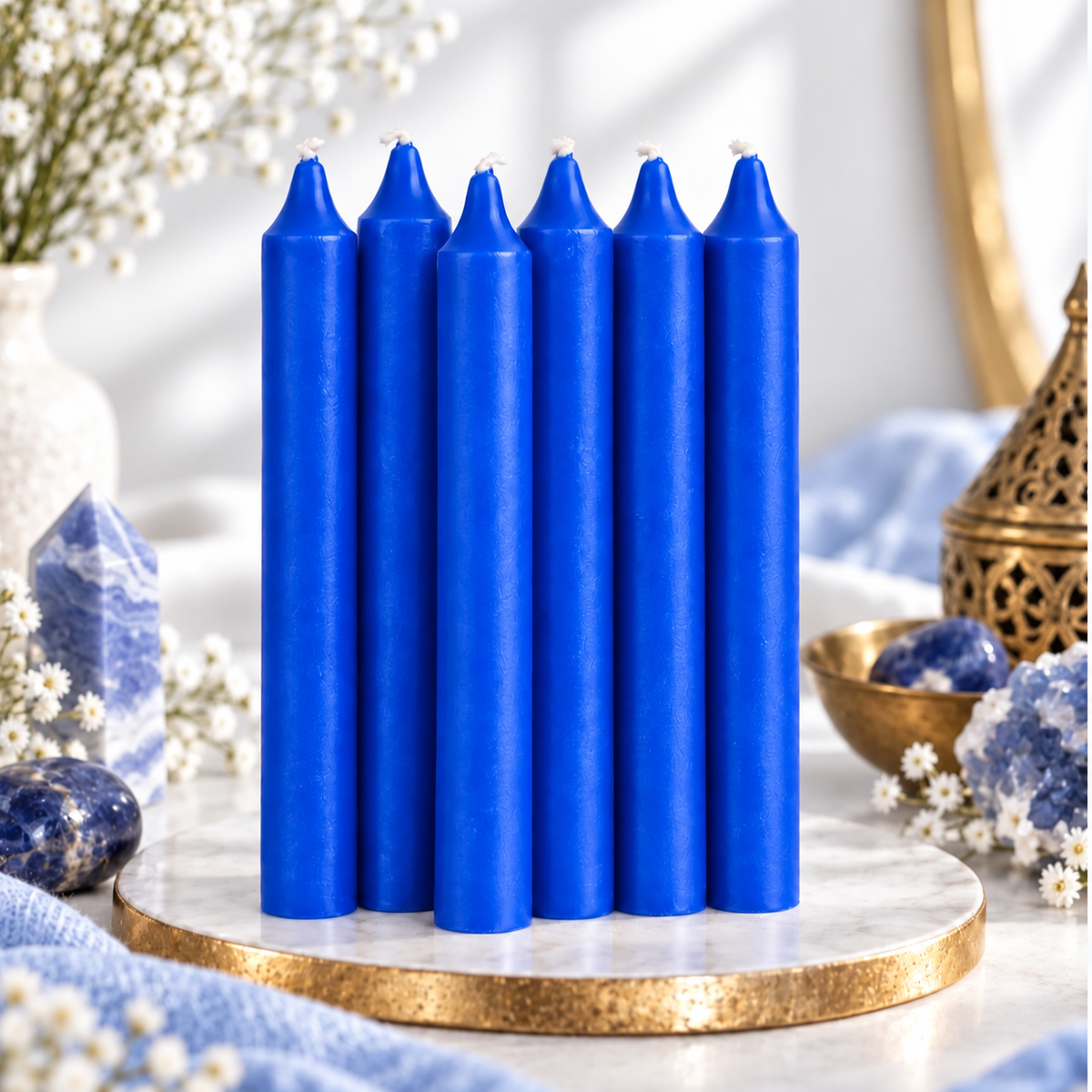 Set of six blue 6-inch intention candles with blue crystals and white flowers on a bright white background