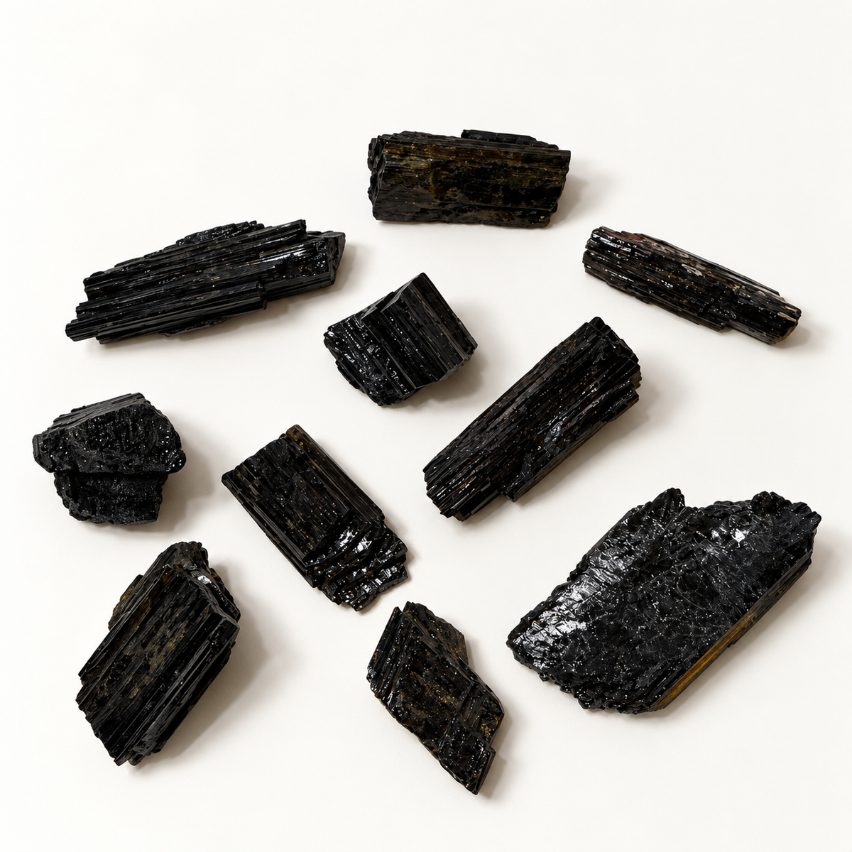 Assortment of natural raw black tourmaline crystals showing their rough black striated surfaces