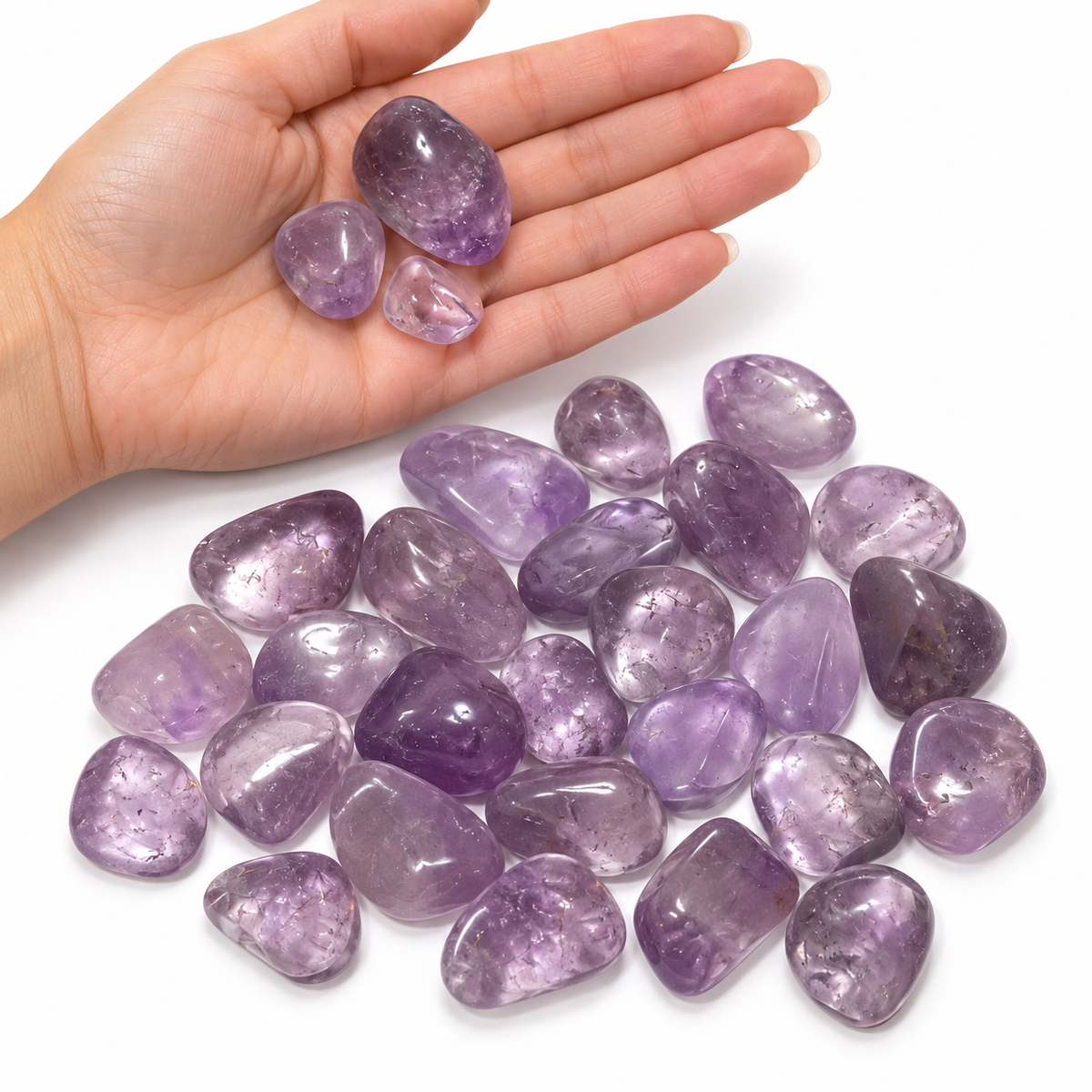 Amethyst tumbled stones shown in hand for size reference