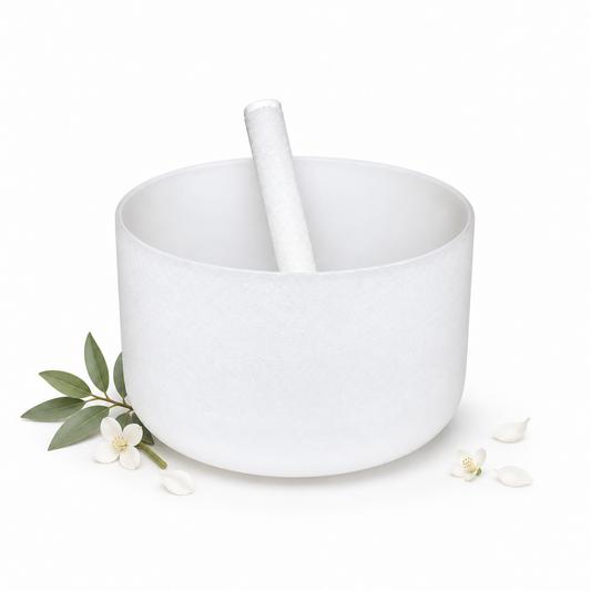 8 inch off-white crystal singing bowl with white mallet, green leaves, and delicate white flowers