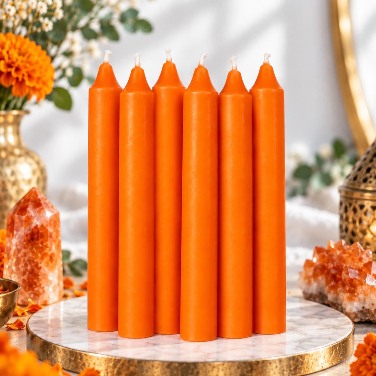 Set of six orange 6-inch intention candles with flowers and orange crystals on a bright white background